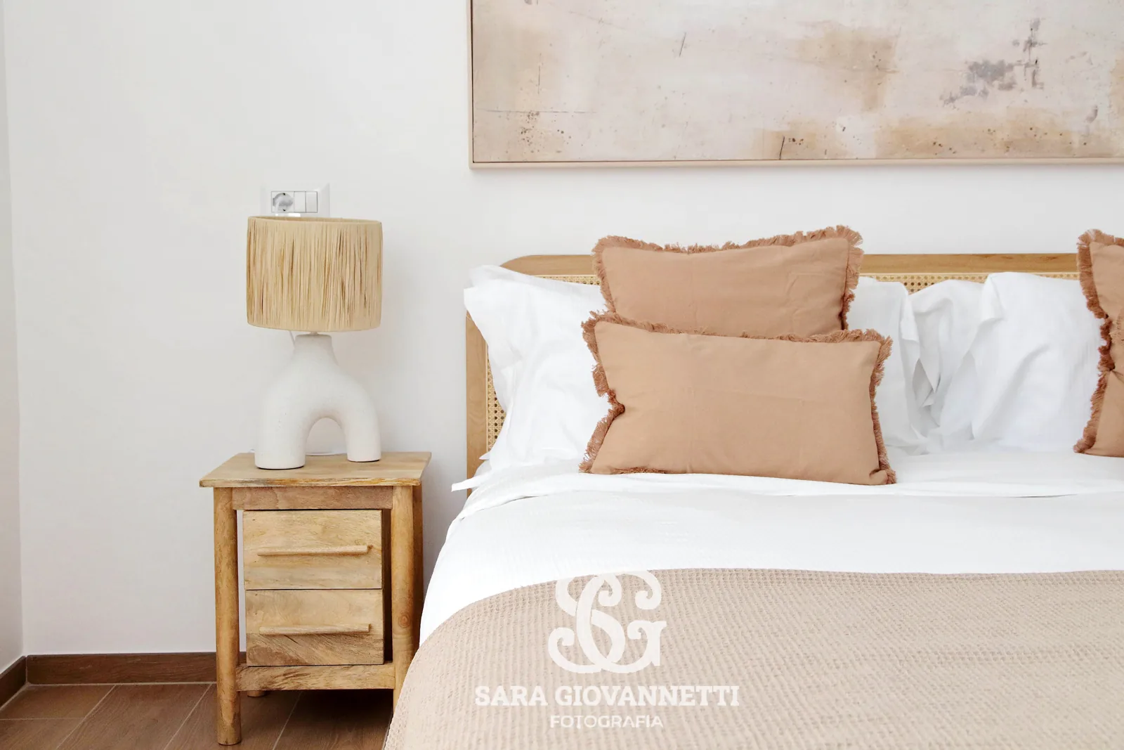 Camera da letto di una casa vacanza fotografata da un fotografo Airbnb Roma: letto in legno, cuscini rosa e lampada in rafia