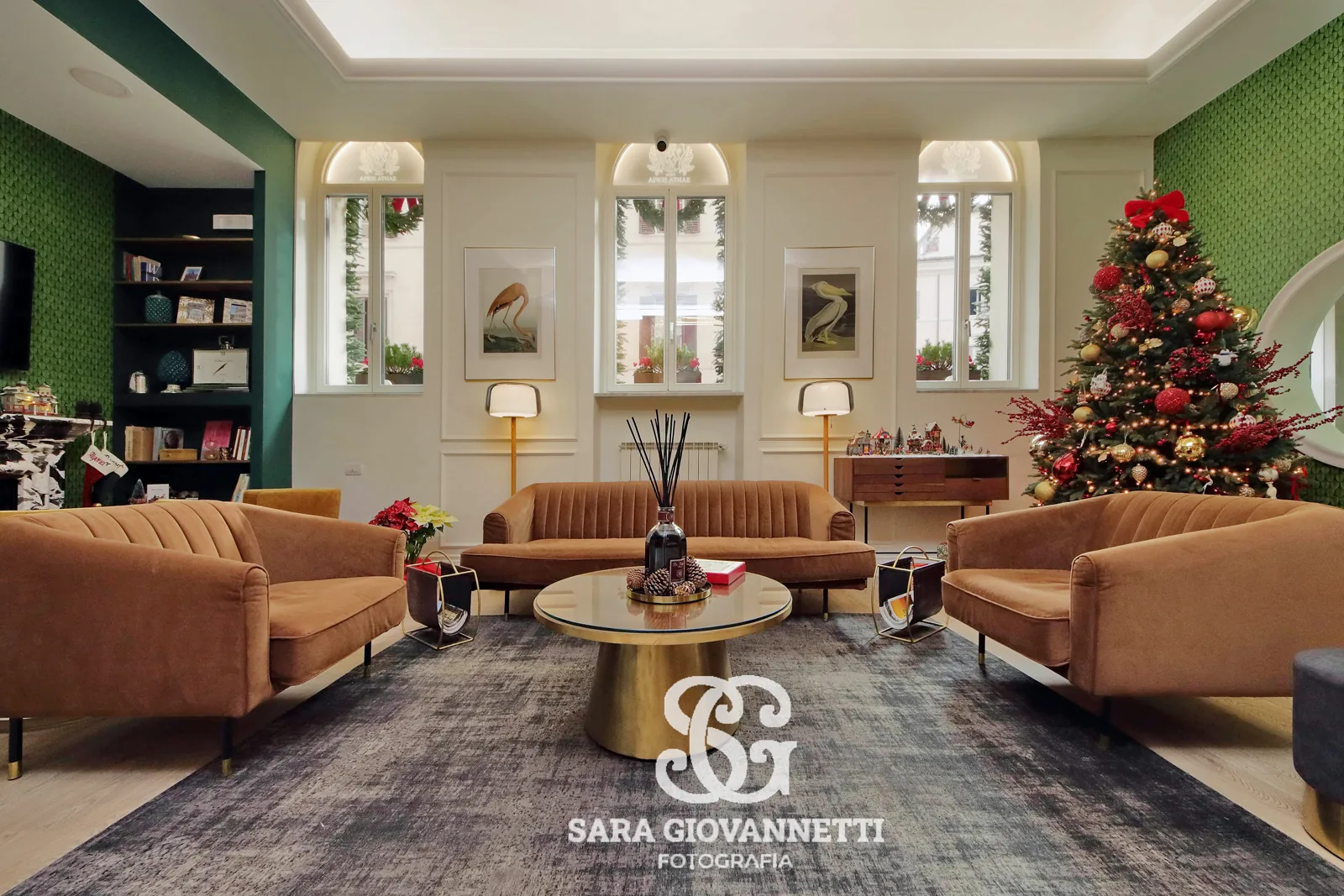 Fotografo Airbnb Roma: soggiorno elegante con divani in velluto ocra, albero di Natale decorato e pareti verdi